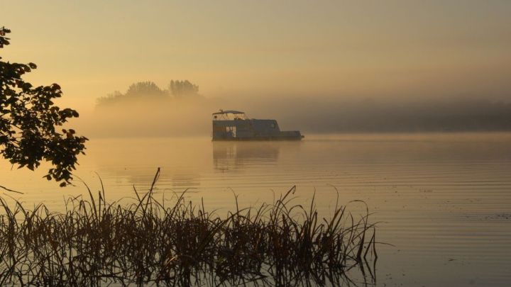 Sonnenaufgang auf dem See: mittendrin ein schwimmender Wohnwagen Sonnenaufgang auf dem See: mittendrin ein schwimmender Wohnwagen
